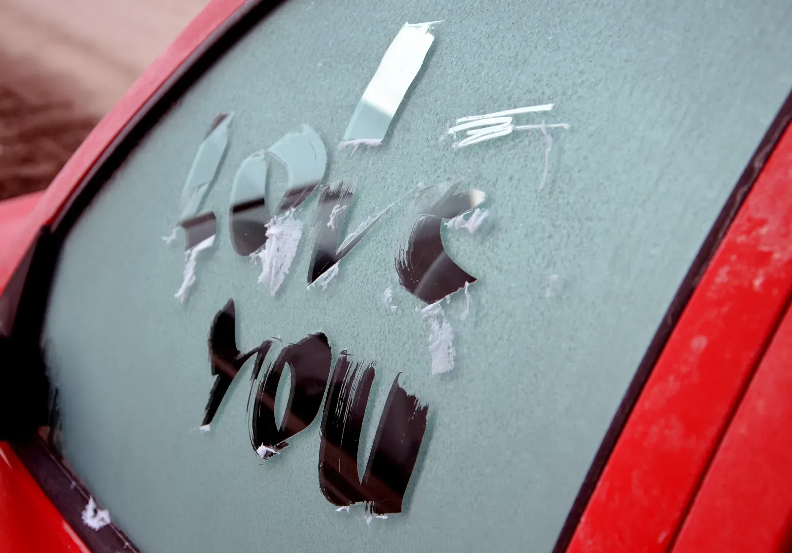 Kleiner Kratzer an einer Autotür auf einem Parkplatz