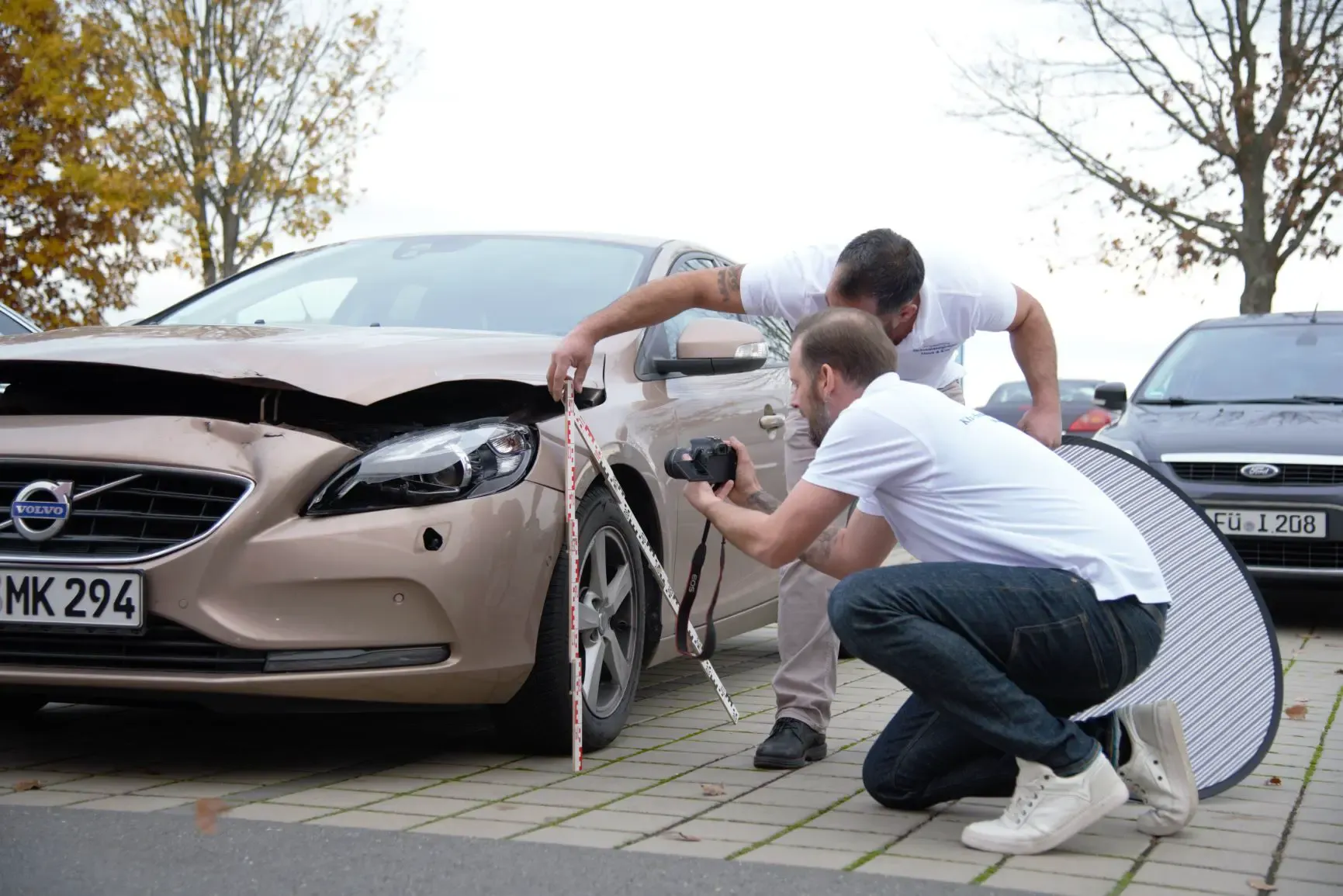 Schadensaufnahme an einem Unfallfahrzeug durch Marek & Kim