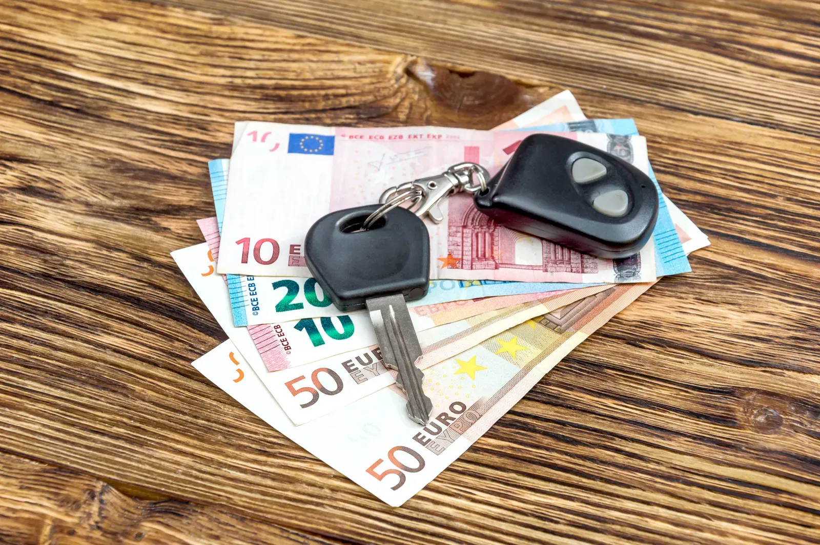 Autoschlüssel mit Geldscheinen als Symbol für Wertverlust